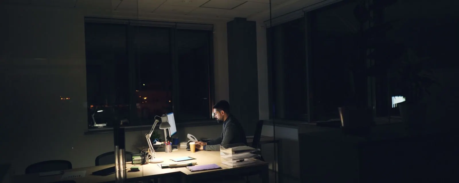 Person working late at a lit desk, illustrating the overtime pay calculator