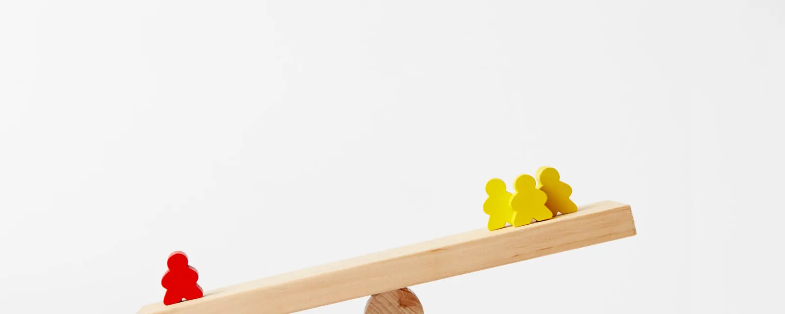 Wooden figures on a tilted seesaw, illustrating highest and lowest sales tax rankings