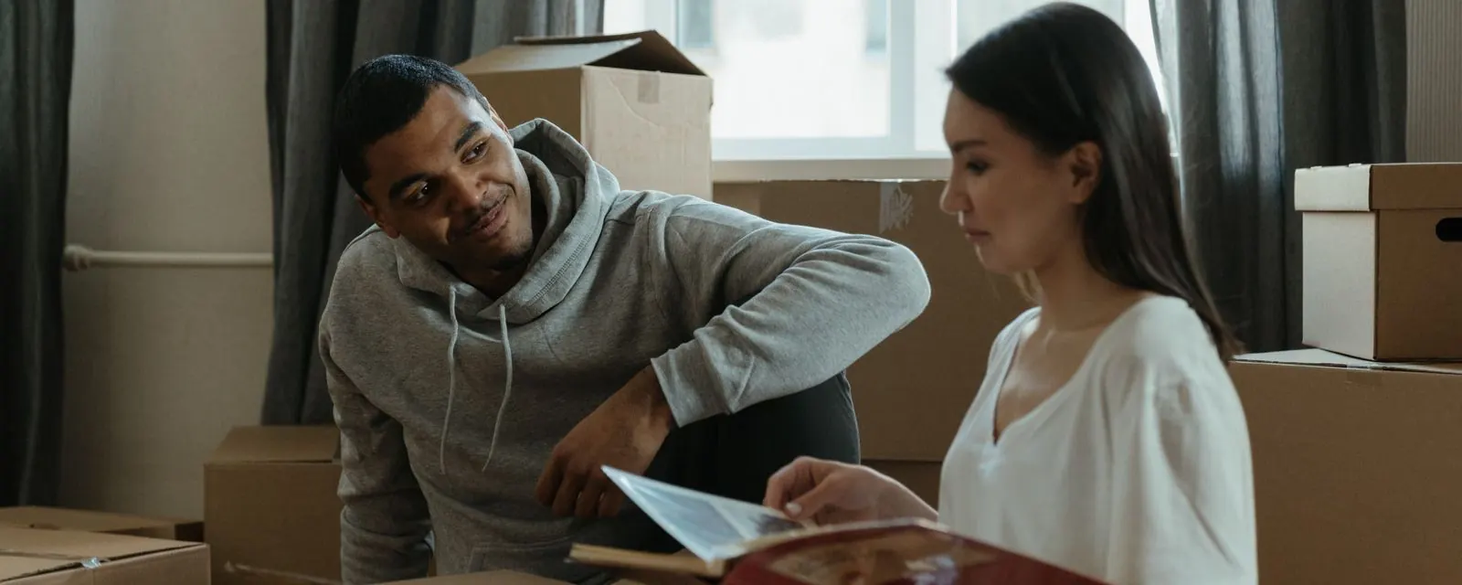 People unpacking boxes in a new apartment, illustrating the moving cost comparison tool