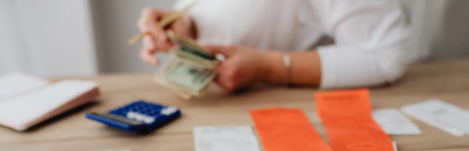 Cash, receipts and a calculator on a table, illustrating local cost of living data