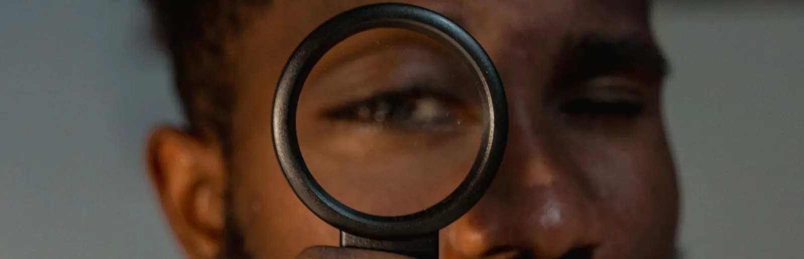 Person looking through a magnifying glass, illustrating the ZIP code and city search