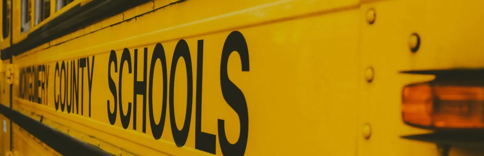 Yellow public school bus parked at dusk, illustrating local school district data