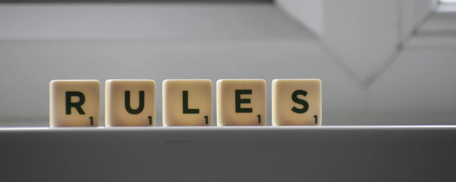 Letter tiles spelling RULES on a windowsill, illustrating sales tax taxability rules