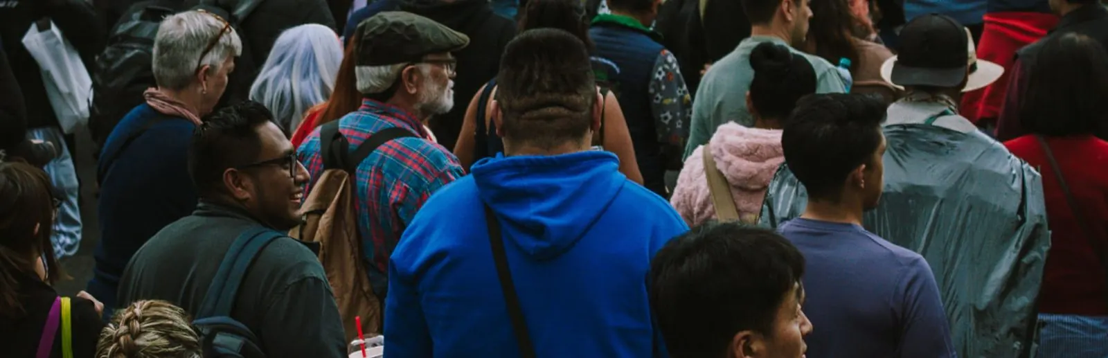 A crowd crossing a city street, illustrating US population and demographics data