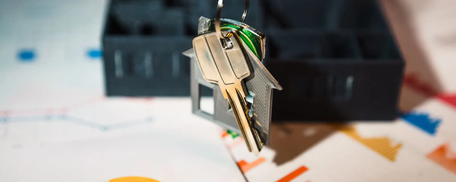House-shaped keyring resting on printed charts, illustrating ZIP-level sales tax lookups