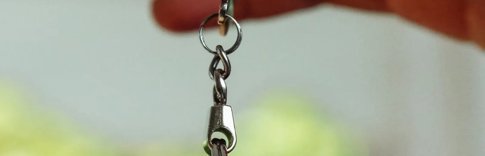 A hand holding a house key outdoors, illustrating local housing and home value data