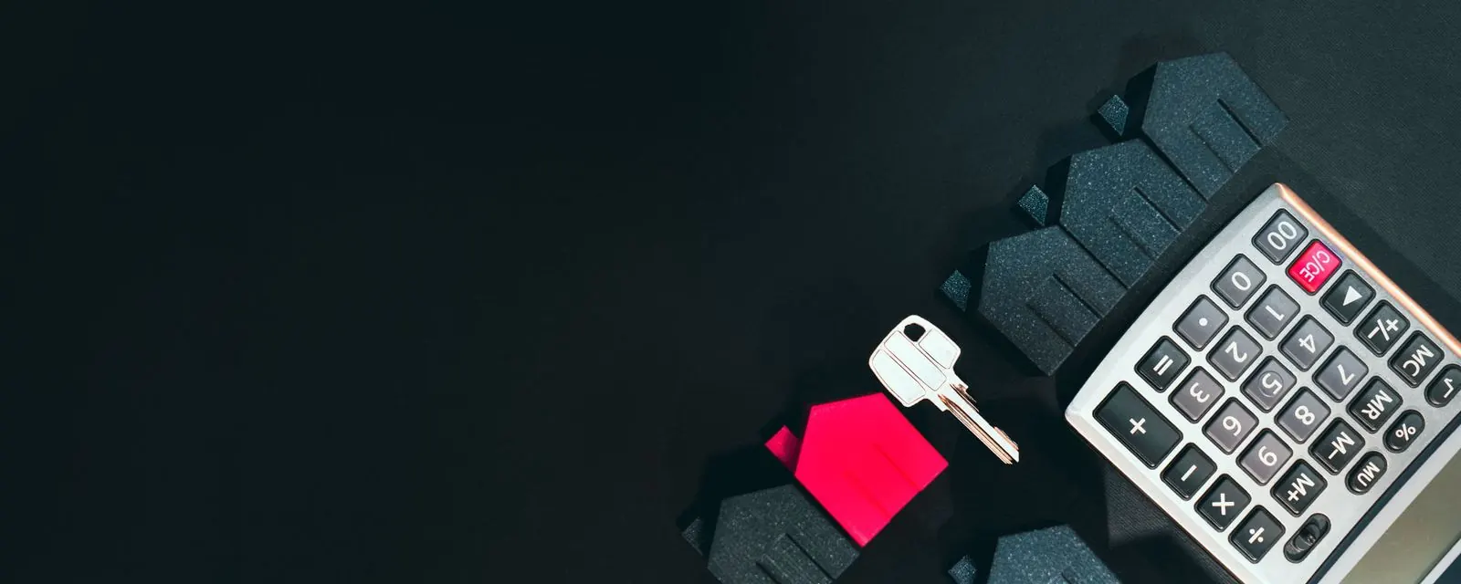 House model, door key and calculator, illustrating the rent versus buy calculator